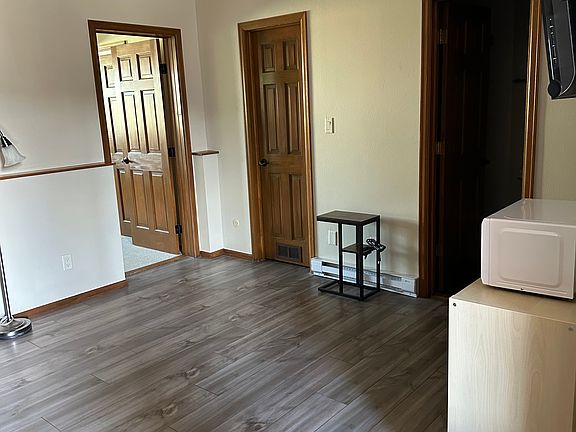 The view of the great room as you enter the home. Bathroom door on the right, followed by the closed laundry room door and then the entrance into the bedroom.