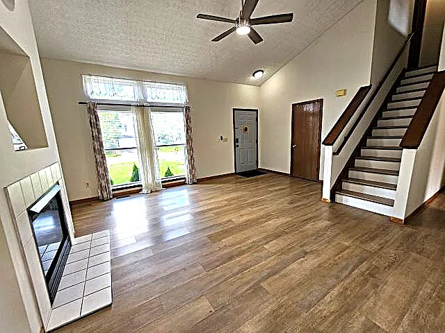 2 Story entry-great room, sunlit windows, closet, ceiling fan, fireplace with fresh paint and laminate flooring.