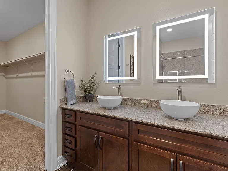 Dual vanities with vessel bowl sinks and LED backlit mirrors