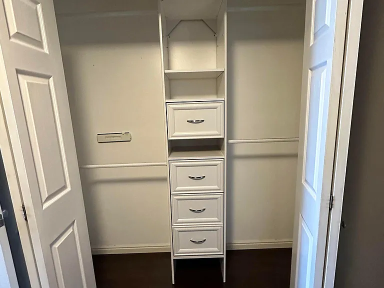 Bedroom closet space with storage drawers built in.