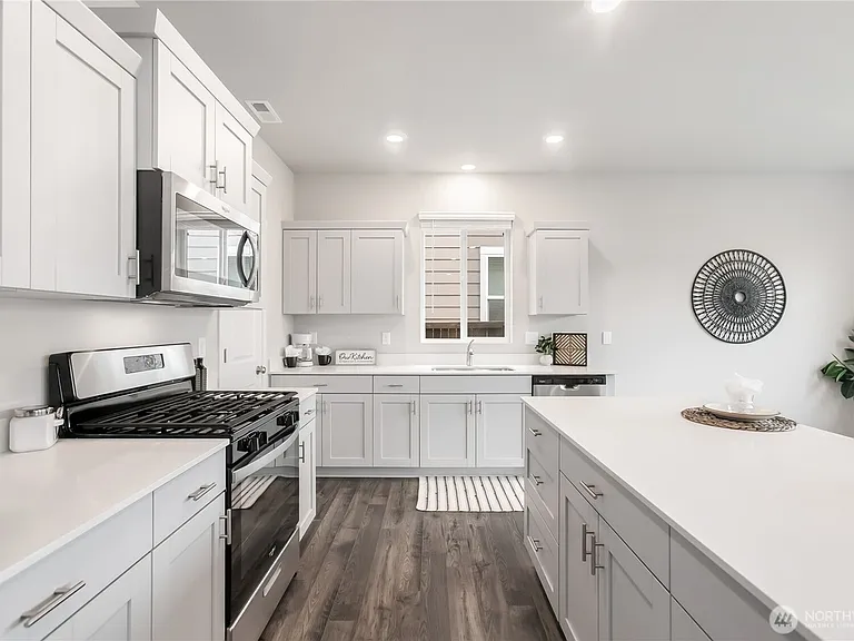 Kitchen with white cabinets and countertops. Stainless steel appliances. large walk-in pantry for storage.