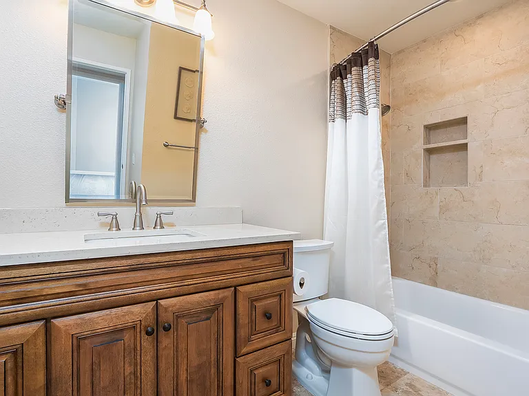 Fully remodeled guest bathroom, with soaking tub and high-end pluming fixtures, including chair-height Kohler toilet.