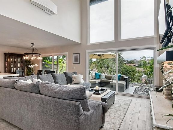 Spectacular full wall to ceiling windows upon entry to open living room.