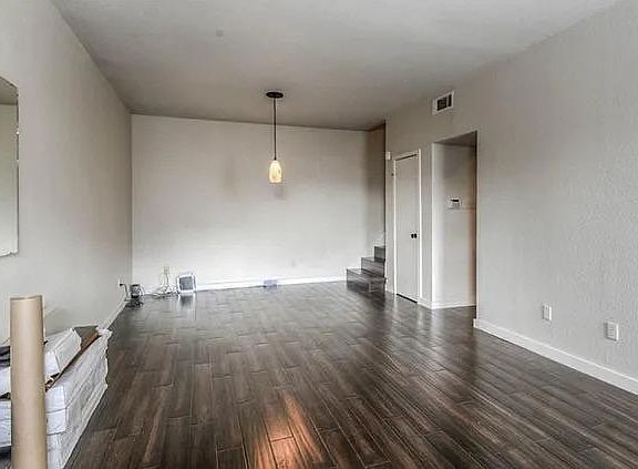 Spacious living area with room for living furniture and a dining table or home office. Note carpet has been replaced with bamboo flooring throughout.