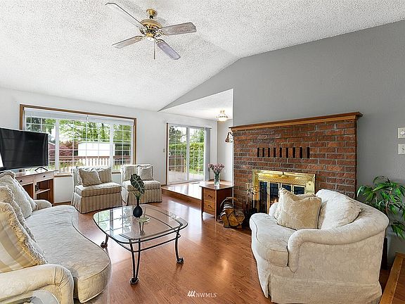 Just off the entry foyer is the lovely and spacious living room. A brick accented fireplace provides character and charm. 
