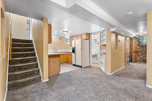 Entryway door leads down a short flight of stairs to the making living space, which is adjacent to the kitchen