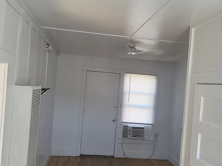 Living room and entry way leading to fully renovated kitchen