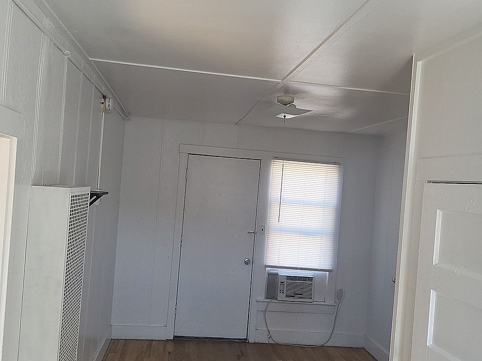 Living room and entry way leading to fully renovated kitchen