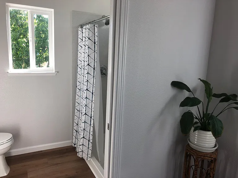 Walk-in shower with quartz panels for easy cleaning.