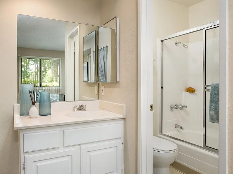 Classic bath with white countertops and white cabinetry