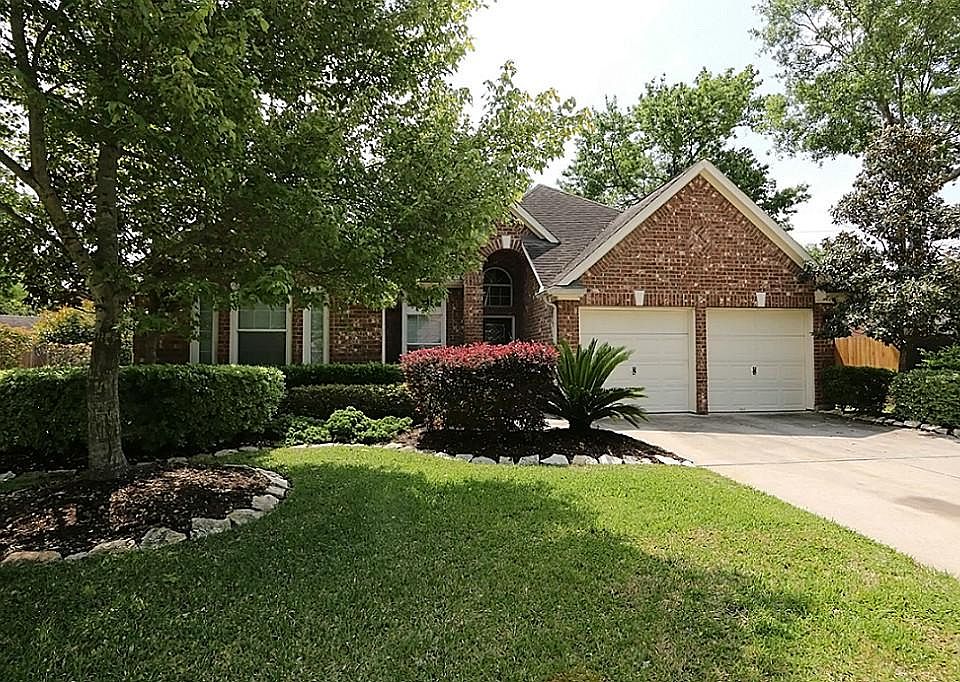 Gorgeous one-story brick home has mature landscaping and great curb appeal in Champions Park.