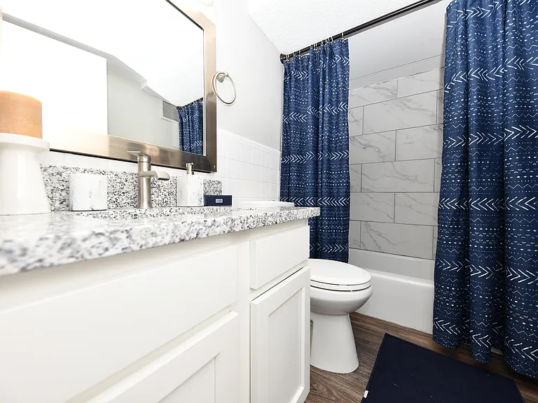 Bright bathroom with granite counters and bathtub