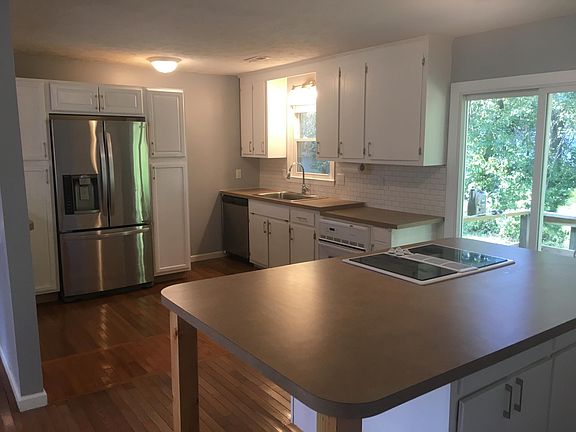 Kitchen includes fridge, oven, cooktop and D/W. Spacious island, built-in fridge, hardwood floors and subway tile backsplash.