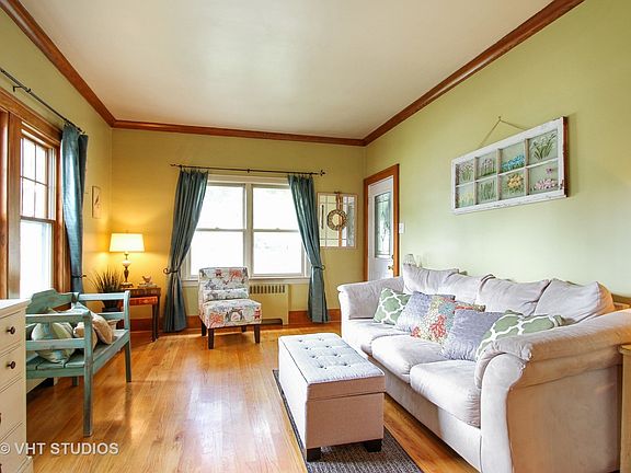 Living Room with hardwood floors, crown molding and plenty of natural sunlight.