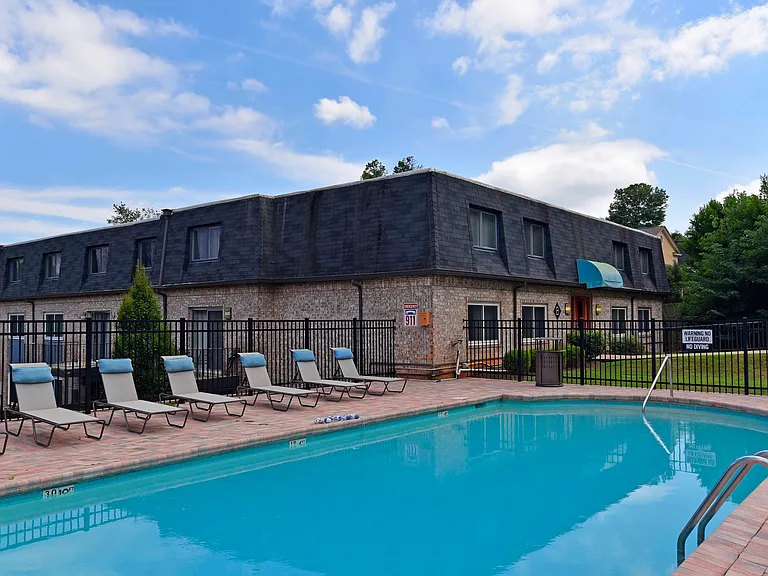 Relax by the pool in this picturesque apartment setting, perfect for sunny day enjoyment.