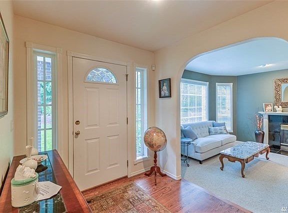Once through the door you have a large entry area.  The leaded glass arch in the entry door is complemented throughout the home with several larger arched designs.  Warm hardwoods enhance this area and carry through down the hallway into the kitchen and f