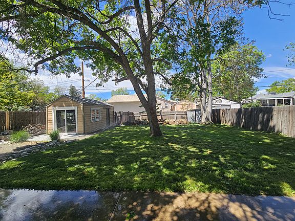 View from back patio to back yard and 3-season bonus space (converted garage, left).