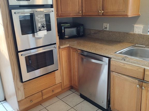 Kitchen with stainless appliances. Double gas oven. Kitchen door next to oven leads outside and close to side door of garage, allowing for private access to garage.