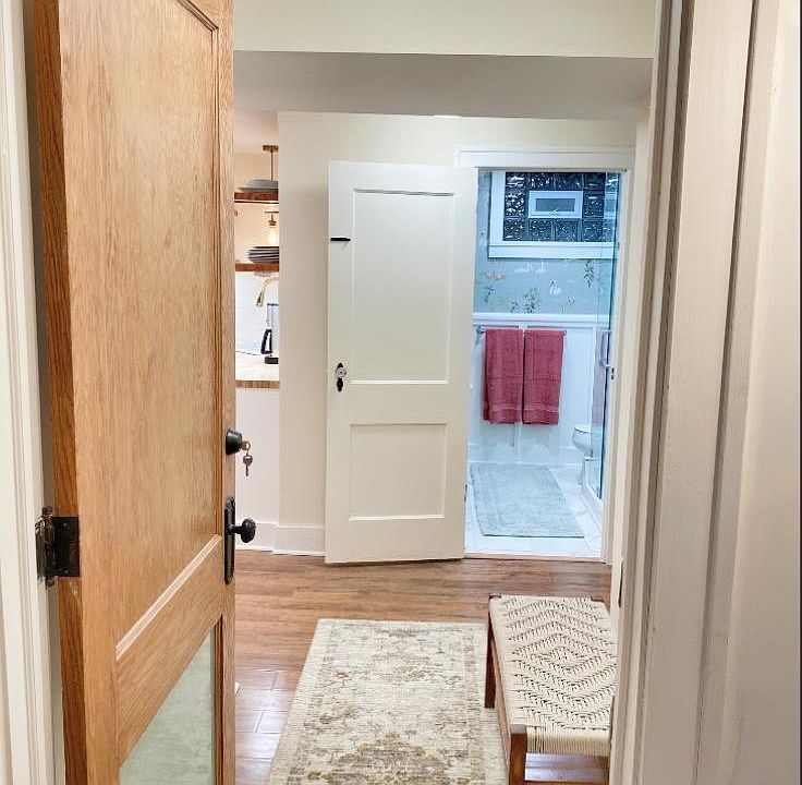 View from entry through hallway with storage to bathroom. Kitchen, dining, living is to the left. Bedroom to the right