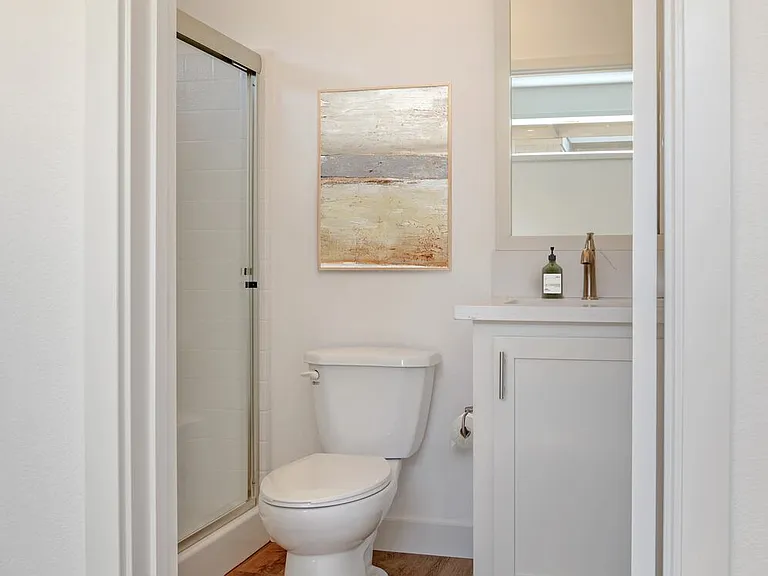 Freestanding Home bath with white quartz countertops, white cabinetry, and hard surface flooring
