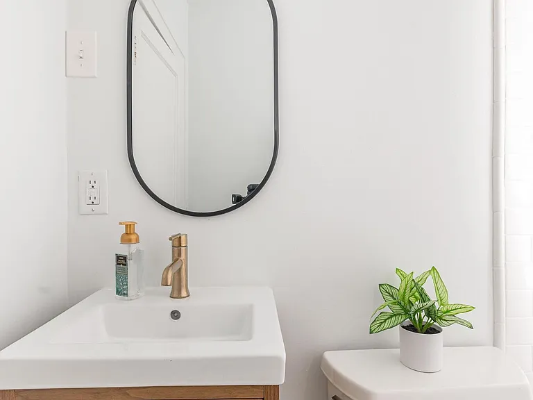 Cute downstairs bathroom with designer vanity, Mitzi lighting, and delta faucets