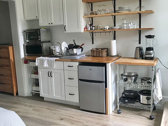 Kitchenette fully furnished, with Breville countertop oven, 'fridge (new one is larger than in the photo), microwave, blender, electric kettle, induction burner, slow cooker, plus the basics: cutlery pots pans plates bowls cups etc.