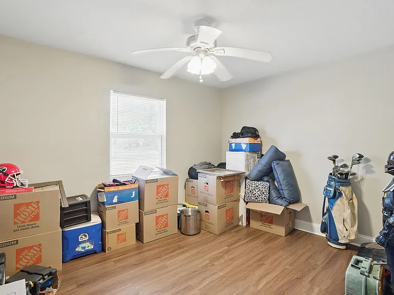 The second bedroom offers cozy comfort with matching luxury vinyl plank flooring, a large window for natural light, and a versatile layout perfect for guests, a home office, or a child's room