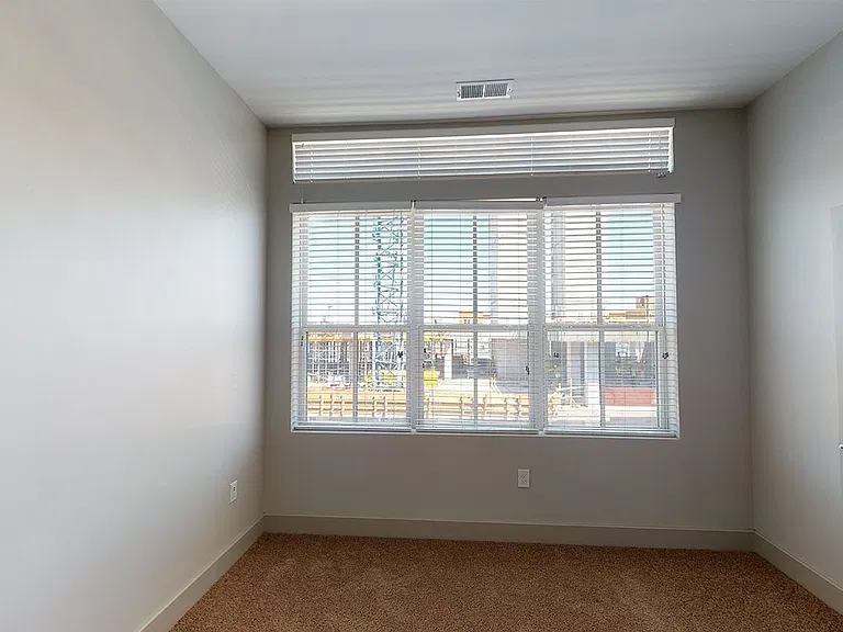 Spacious apartment bedroom with plush carpet flooring