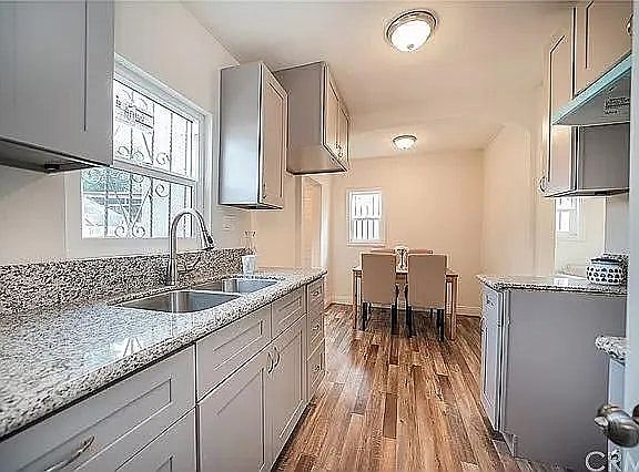 Sleek kitchen with granite counters, light cabinetry, and stainless sink.