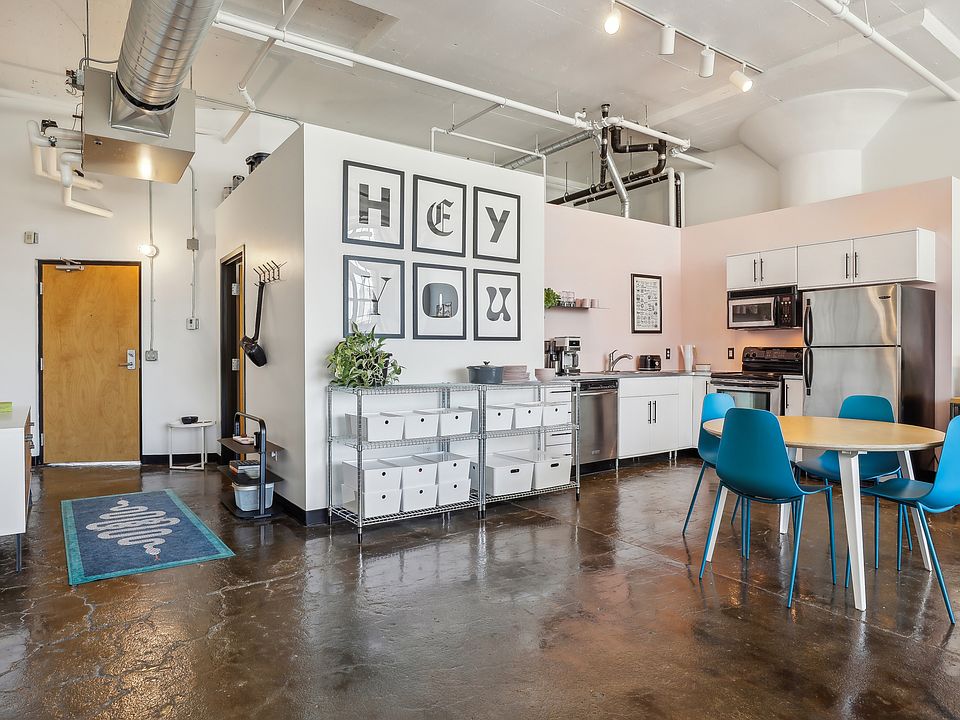 Modern stainless steel appliances, polished concrete floors, and soaring ceilings.
