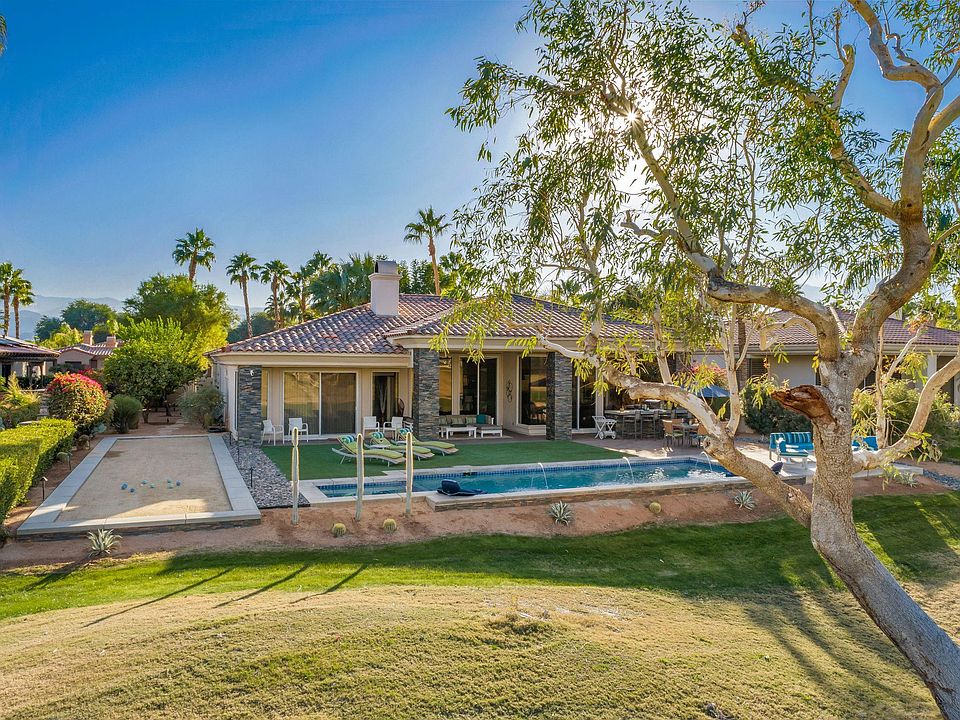 Rear of home with pool and bocce ball court.