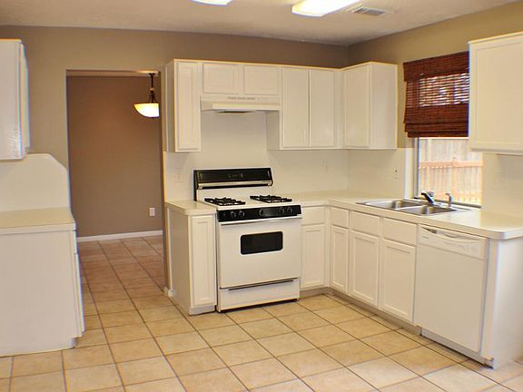 The kitchen has durable tile floors, formica counters, and solid cabinets.