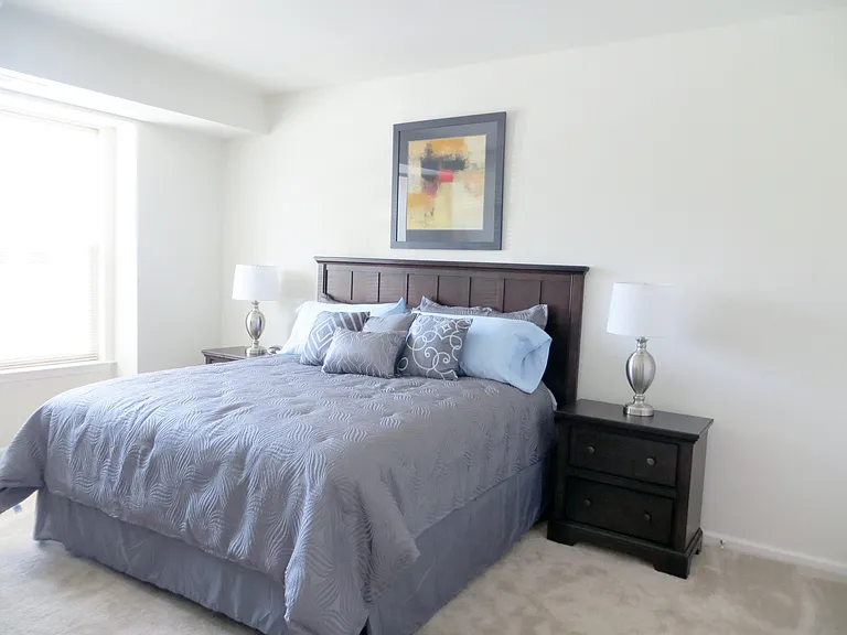 Spacious primary bedroom with over sized windows with blinds.