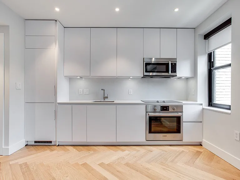 Century studio kitchen with dishwasher, integrated fridge and granite counters