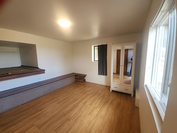 Interior showing sleeping alcove on left and freestanding wardrobe. The window on your right looks out to the deck and eastwards.