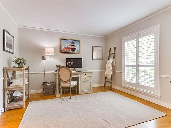 Study located off of formal living room has fresh paint, plantation shutters, crown molding and hardwood floors.