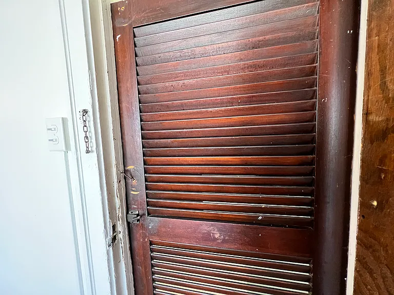Main room entry door has its original wooden screen door.