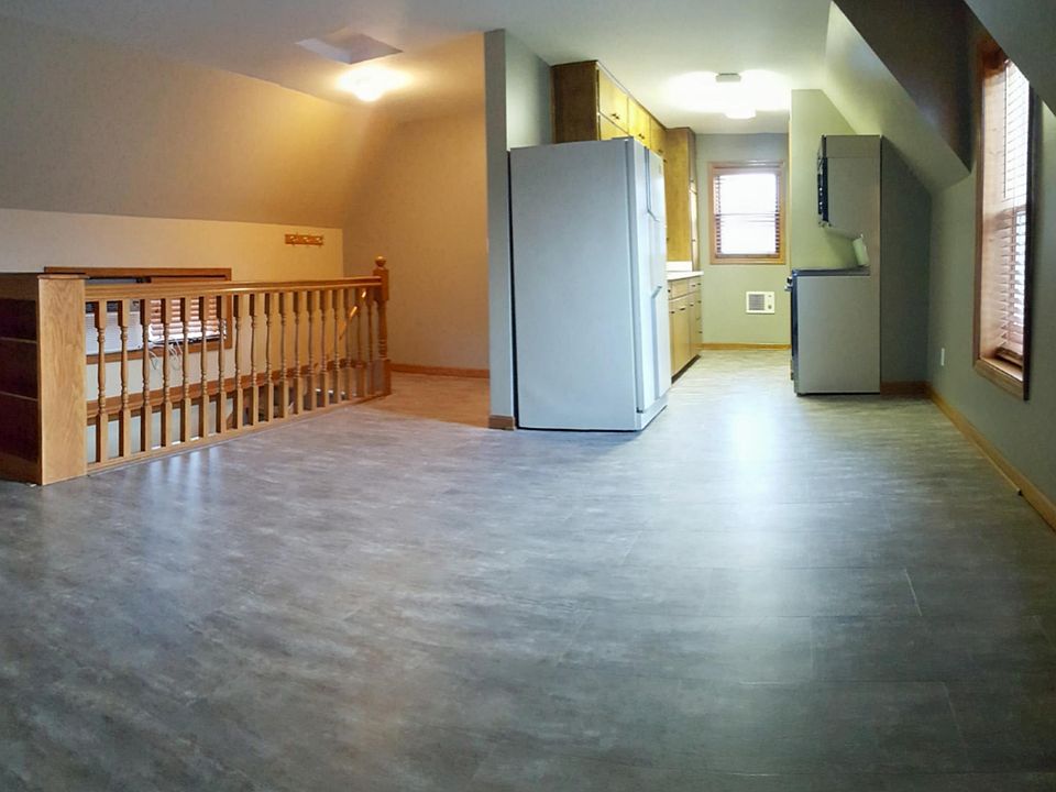 Open floor plan in the main living area / kitchen. New plank flooring and fresh paint in gray / neutral tones .