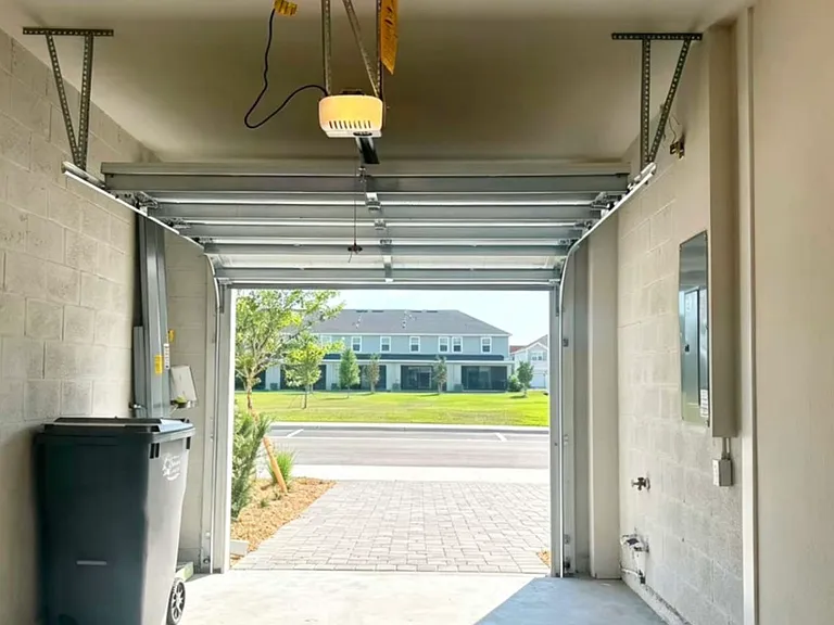 garage with hurricane shutters, and extra guest parking outside right opposite to the unit