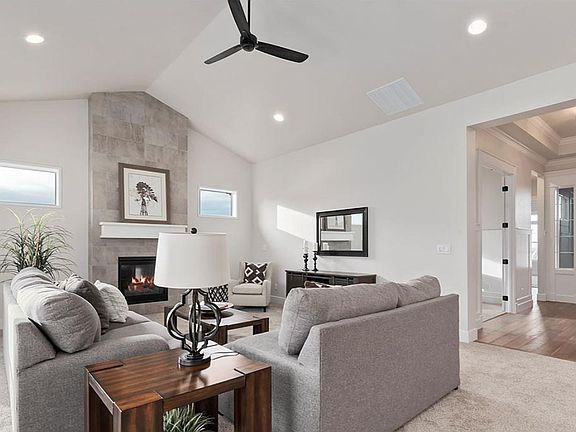 Spacious, oversized living room with vaulted ceilings, beautiful fireplace with high-end, modern grey tile.