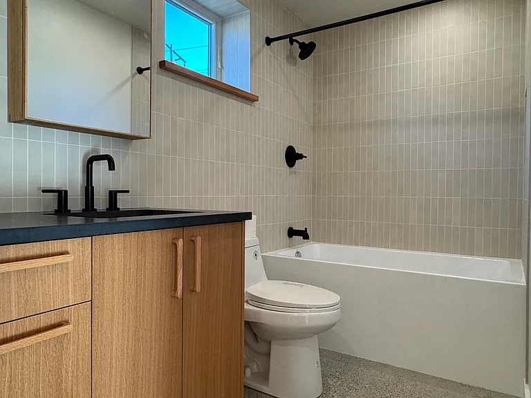 Primary bath with soaking tub, white oak cabinets, quartz counters on 1st floor.