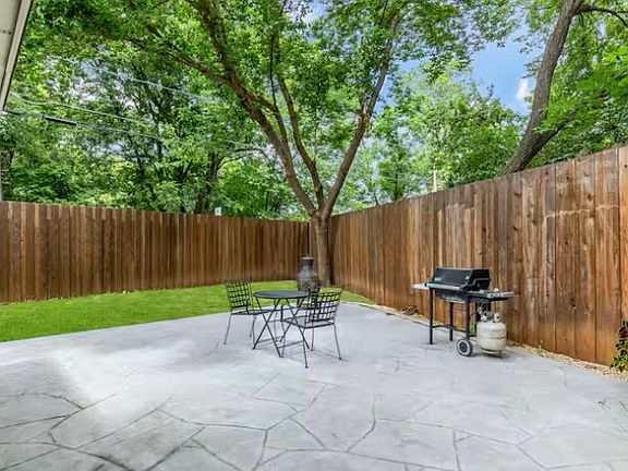 Private back yard with custom patio, grill, and outside patio. The entire home is surrounded by an 8 ft privacy fence