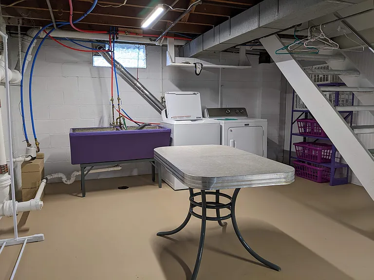 Washer, Dryer, table for folding laundry, and shelves for sorting clothes.