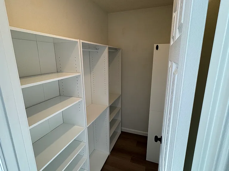 Large walk_in closet with built_in shelving for easy organization.