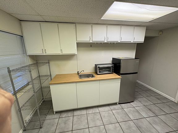 Kitchenette - view of cabinets, sink, toaster oven, and fridge