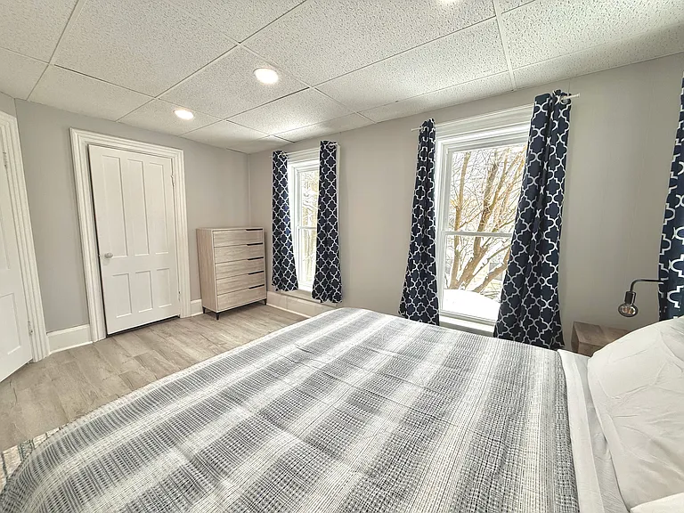 This master bedroom features a comfortable king-size bed and a spacious dresser, providing plenty of storage and a relaxing space to unwind.