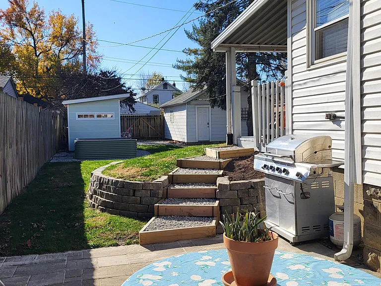East side patio looking south. Garden shed with raised beds, detached garage at back of property.