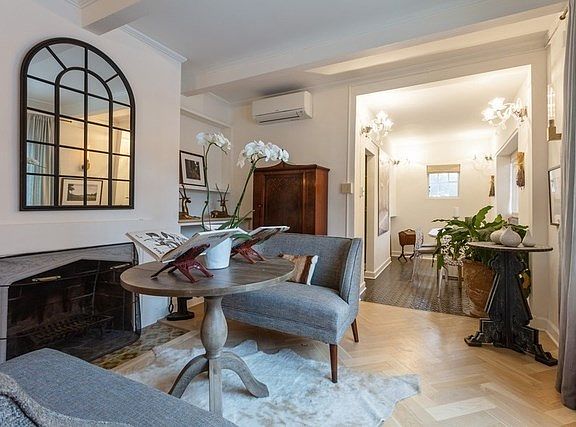Fully remodeled in 2018, the living room features two seating areas and custom built-in cabinetry su