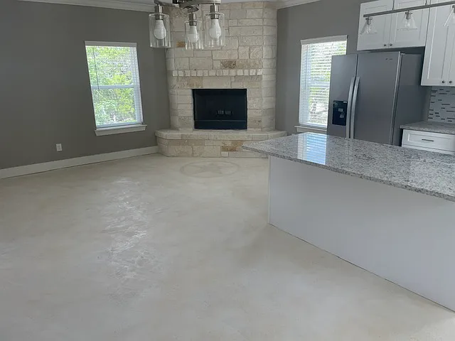 Small living area with floor to ceiling limestone wood burning fireplace.