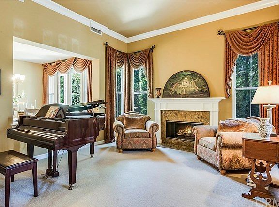Grand formal living room with crown molding and custom drapes.